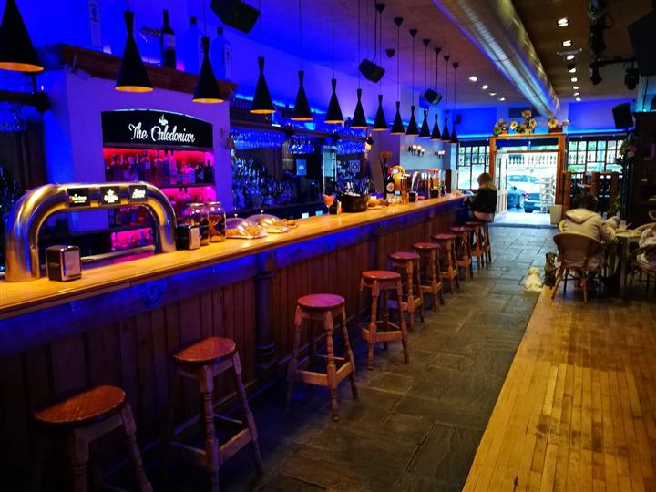 La barra de madera con taburetes y luces de neón azules