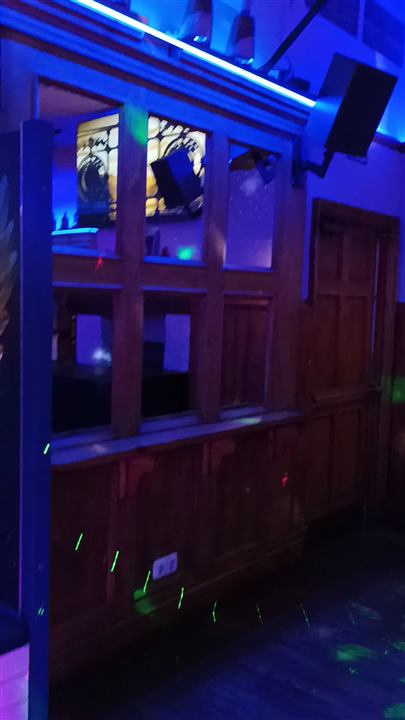 La zona de la pista con luces láser y cabina del DJ